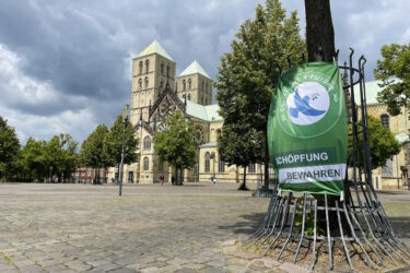 Dom Münster im Hintergrund, davor Plakat zu Schöpfungsbewahrung