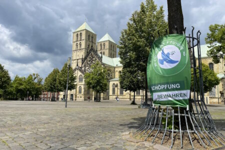 Dom Münster im Hintergrund, davor Plakat zu Schöpfungsbewahrung