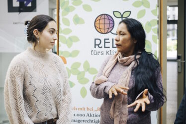 Zwei Frauen unterhalten sich: eine Schülerin und Celia Fasabi aus Peru