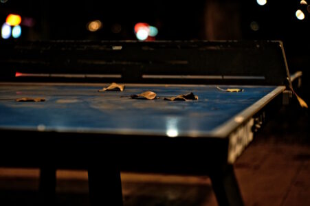 Tischtennisplatte im Dunkeln mit Licht im Hintergrund